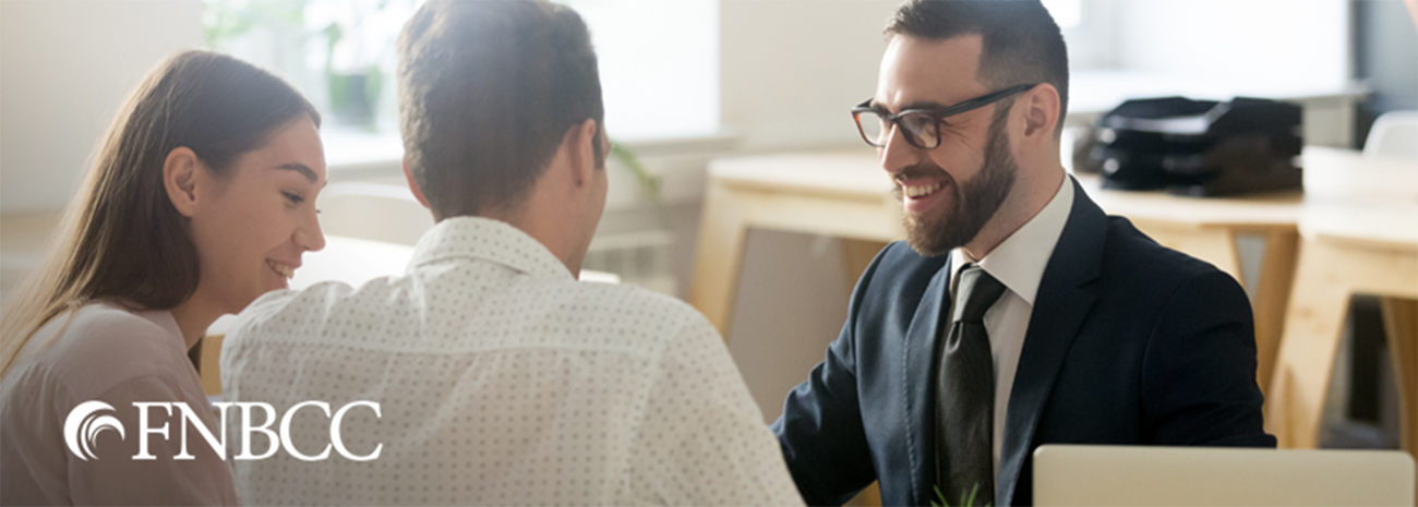 Man and woman smiling while talking to male banker
