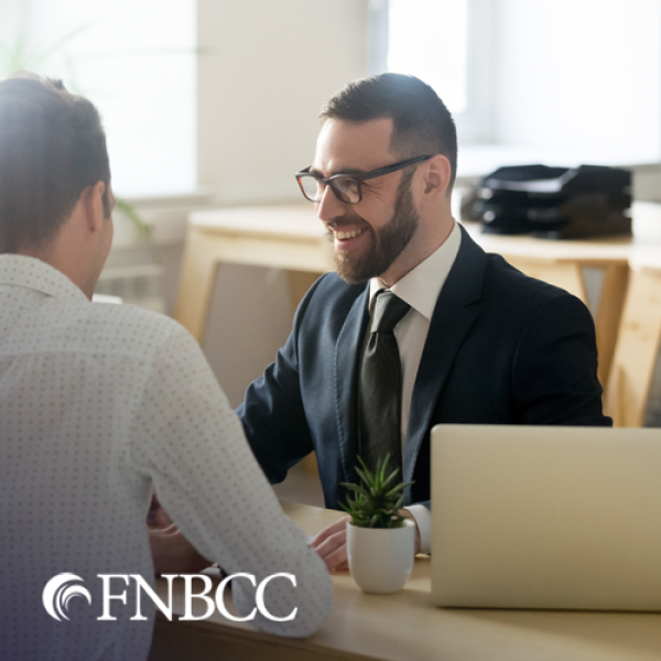 Man and woman smiling while talking to male banker