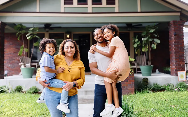 family in front of new home